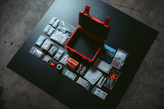 HARD Case first aid and trauma kit contents laid out around the waterproof red case