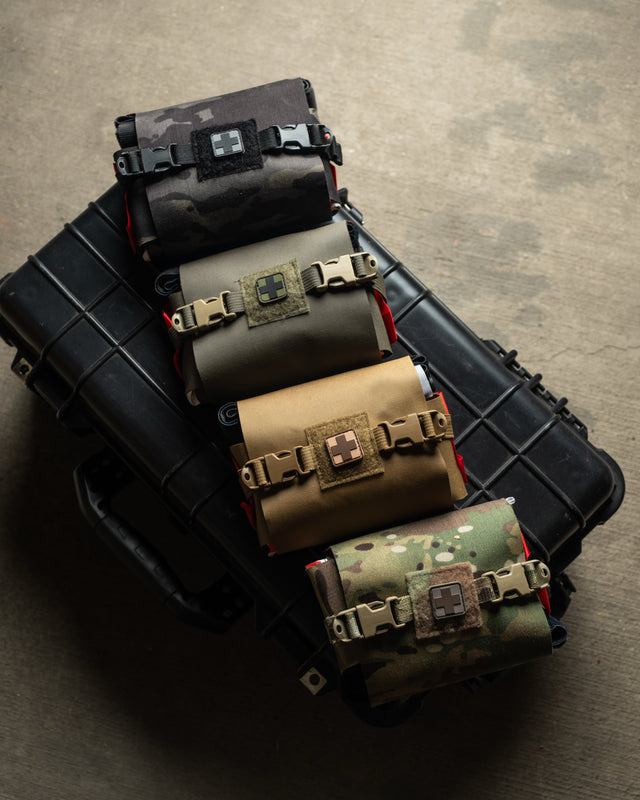 S.P.E.A.R. trauma kits in multiple colorways stacked on a hard case