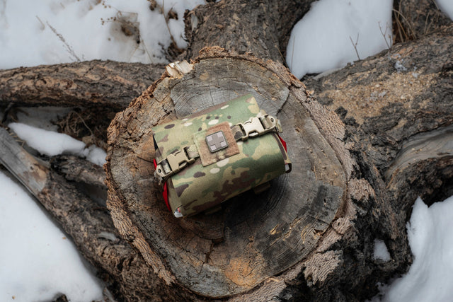 S.P.E.A.R. trauma kit resting on a snowy tree stump