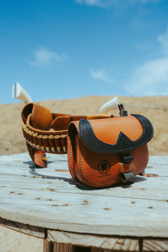 Frontier T.R.A.I.L. leather trauma kit on a cartridge belt with a hatchet in a western scene