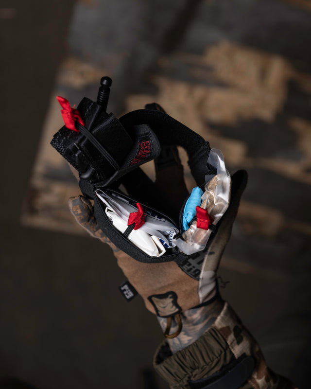 Loaded ankle trauma kit rig held in a gloved hand