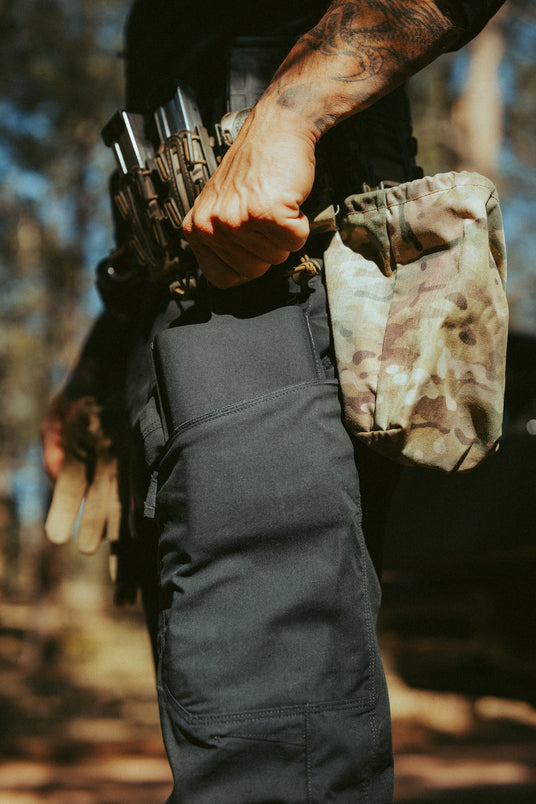 Officer holding the Blue Line trauma kit beside a duty belt with a dump pouch
