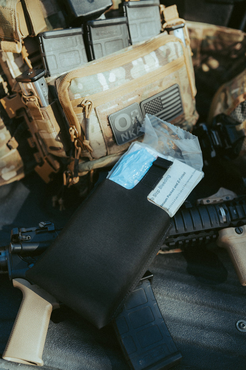 Blue Line trauma kit staged with a plate carrier and duty gear