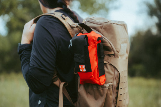 D.A.R.K. Trauma Kit attached to a hiking backpack on the trail