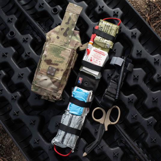 D.A.R.K. Trauma Kit with its full contents laid out, including tourniquet, hemostatic gauze, chest seals, and trauma shears