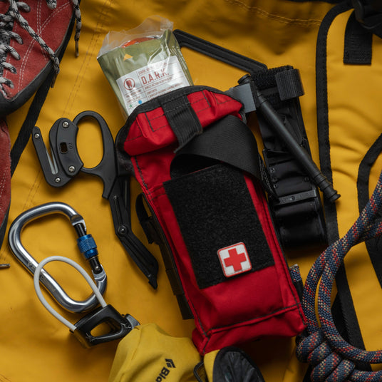 D.A.R.K. Trauma Kit with the vacuum-sealed insert pulled from the pouch, tourniquet and shears alongside