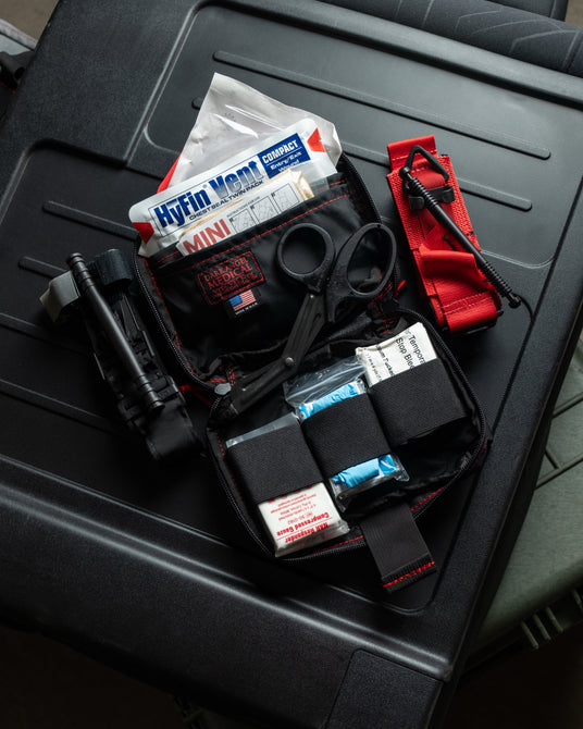 HEDR headrest trauma kit contents including chest seals, hemostatic gauze, tourniquet, and shears