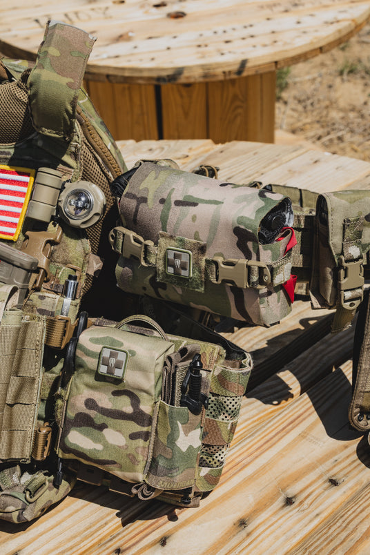 Family of Dark Angel Medical trauma kits mounted on a multicam plate carrier