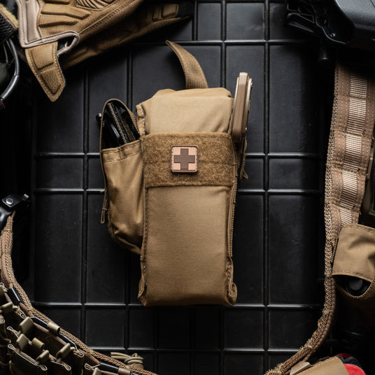 Coyote Brown D.A.R.K. Slim Trauma Kit mounted on a plate carrier