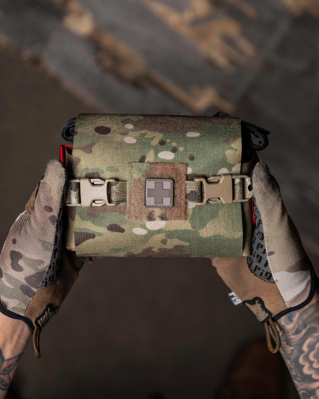 Multicam S.P.E.A.R. trauma kit held in gloved hands