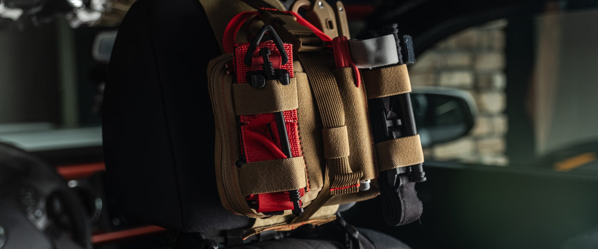 Coyote brown HEDR trauma kit mounted on a vehicle headrest inside the cab