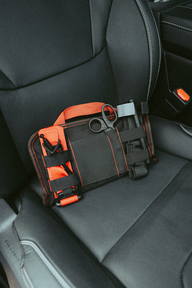 VISR low-profile visor trauma kit with tourniquet and shears staged on a car seat